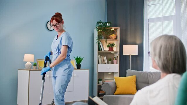 social protection service for pensioners, a young female employee in uniform takes care of pensioners and helps with cleaning apartment