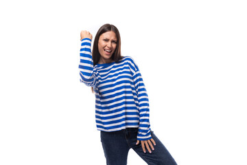 European pretty brunette young lady in a casual striped sweater and jeans gesticulates with her...