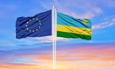 European Union and Rwanda two flags on flagpoles and blue cloudy sky . Diplomacy concept, international relations