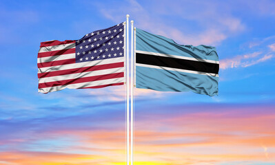 United States and Botswana flags on flagpoles and blue cloudy sky . Diplomacy concept, international relations