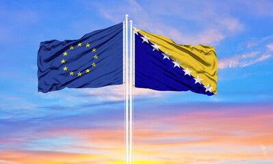 European Union and Bosnia and Herzegovina two flags on flagpoles and blue cloudy sky . Diplomacy...