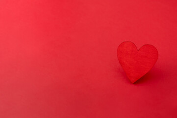 Red wooden heart on red background. Love, valentines day card