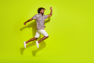 Fototapeta na wymiar Full length photo of nice young male jump running fast wear trendy pink leopard print garment isolated on yellow color background