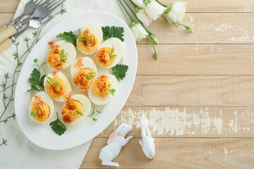 Easter stuffed eggs. Traditional Easter brunch or dinner with stuffed eggs with paprika, carrot...