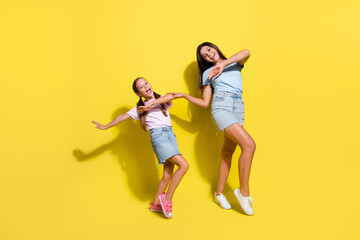 Photo of positive cheerful girls enjoy free time together dancing isolated over vivid color background