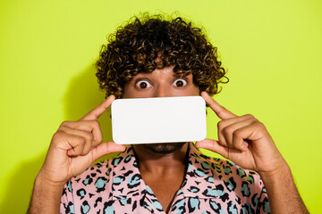 Photo portrait of attractive young man gadget cover mouth screen wear trendy pink leopard print clothes isolated on yellow color background