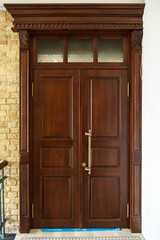 A closed wooden door inside. Interior design, dark red door with metal handle and lock. Evacuation...