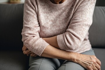 A woman sitting on a couch with her arms crossed. This versatile image can be used to depict a confident or stubborn attitude in various contexts - obrazy, fototapety, plakaty