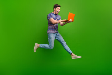 Full size photo of astonished ecstatic guy flying hold laptop astonished staring at fast internet...