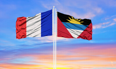 france and Antigua and Barbuda two flags on flagpoles and blue cloudy sky . Diplomacy concept, international relations