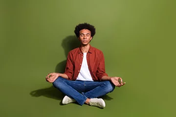  Full length photo of nice young man sit floor meditation lotus pose dressed stylish brown garment isolated on khaki color background © deagreez