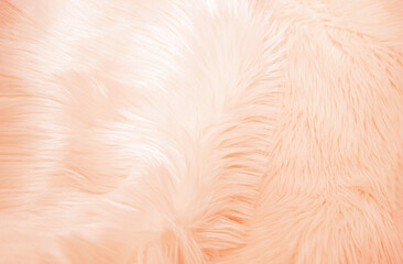 peach colored fur texture. Long pile faux fur background, close-up