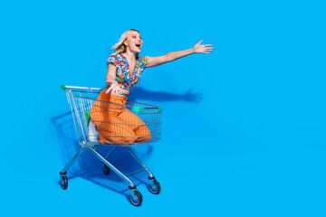 Full size photo of adorable girl wear blouse riding in trolley catching product from empty space...
