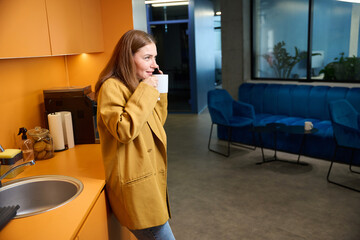 Woman manager with a cup of tea communicates on phone