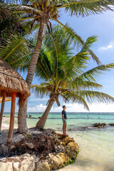 Mężczyzna na rajskiej plaży pod palmami - obrazy, fototapety, plakaty