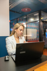 Obraz premium Woman in classic clothes sits at laptop with open screen immersed in work. Contemporary workplace creates pleasant working atmosphere