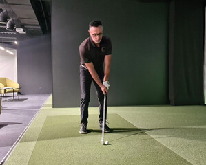 Man playing golf on screen and golf simulator concept