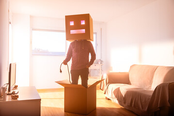 Faceless man with box on head holding power cord