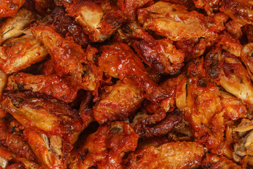 Roasted buffalo chicken wings in a baking tray.
