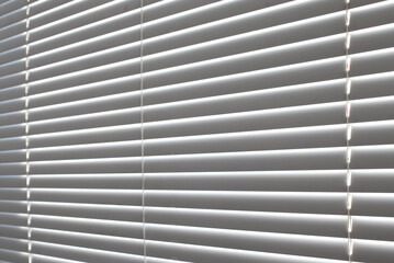 Close-up of white plastic blinds on a window