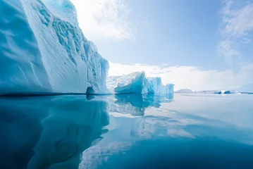 Foto op Plexiglas The image depicts a massive iceberg in the polar regions, surrounded by icy waters. The iceberg's imposing size and jagged edges are a testament to the raw power. climate change. © Robert Kiyosaki