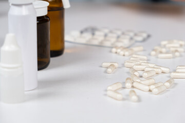 A lot of white capsules are scattered on the table. Drug concept, pharmacy. Place for text