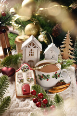 A cup of coffee and house shaped gingerbread cookie for Christmas