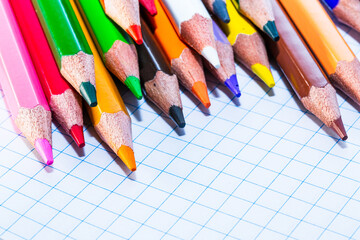 A row of colored pencils sitting on top of a piece of paper. A Rainbow of Colored Pencils on a...