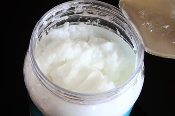 organic coconut cream oil in jar in black background,top view