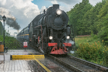 Fototapeta na wymiar Retro steam train approaches to the platform.