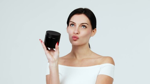 Portrait of a charismatic young woman using face creams. Concept of fresh moisturized skin, beautiful cosmetic face, happy healthy model. A young brunette takes care of her skin.