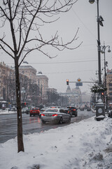 KYIV, UKRAINE - DECEMBER 8, 2023: FROM THE VERY MORNING THE CITY SWEEPS WITH SNOW. THE REAL WINTER HAS BEGUN. PEOPLE GO TO WORK AND CARS PASS BY. SOMETIMES THERE ARE TRAFFICKS. SLIPPERY ROAD.