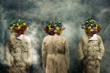 Three men in raincoats with hanging bouquets of flowers. 