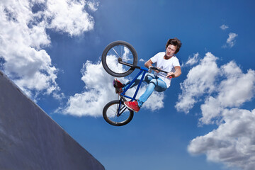 Ramp, jump and man with bike in sky at park, event or competition for sport with risk and energy....