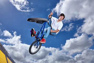 Trick, jump and man with bike in sky at park, event or competition for sport with risk, energy or...