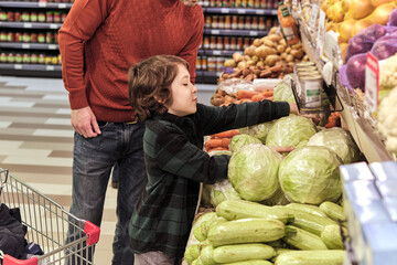 The youngster's action of selecting lettuce demonstrates the hands-on approach to learning about where food comes from and the importance of including greens in one's diet.