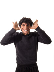 Young handsome man forcing himself to smile, pulling mouth up with his hands, isolated on white background in studio shot