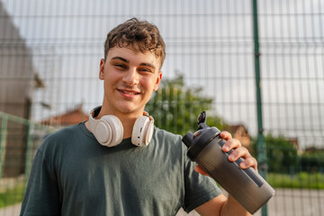 one young caucasian man teenager hold supplement shaker stand outdoor