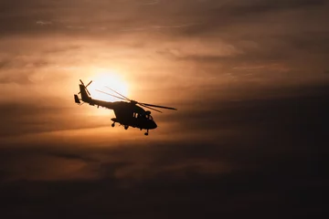 Fotobehang Indian Navy Helicopter flying off into setting sun © neel