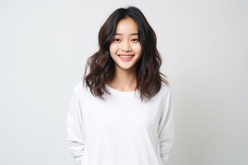 Fototapeta premium Cheerful Asian Teen In Front Of Plain White Studio
