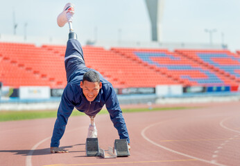 Sport man athlete with a prosthesis on his leg lie down and action of stretch one leg back and up...