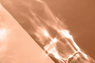 Abstract shadow sun glare from glass, empty background composition for product presentation. The background is beige. Showcase Nude Studio Minimal. Beautiful trendy peach fuzz color background.
