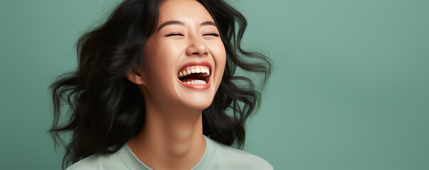 cheerful asian young woman with a smile presenting an idea while standing alone on a color background. banner for beauty salons