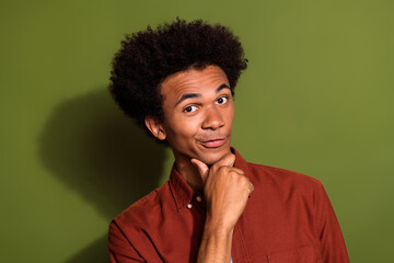 Fototapeta na wymiar Photo of funny clever man with afro hairstyle dressed brown shirt hand on chin think business ideas isolated on khaki color background