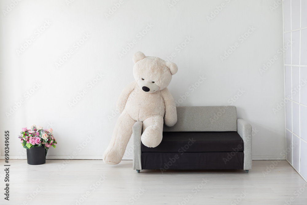 Poster sofa with bear toy in white room interior