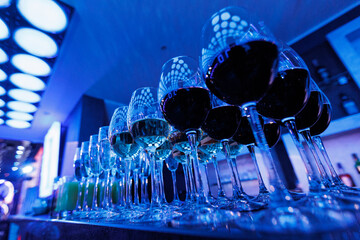 A row of wine glasses in neon light