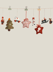 Small decorative wood Christmas toy hang garland on beige gray wall.