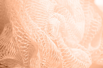 Texture of a colored nylon washcloth close-up. Color peach fuzz