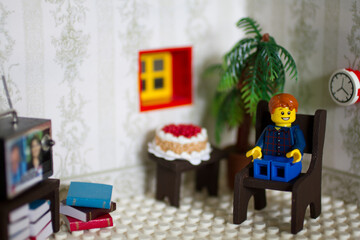 Cozy Lego Figure Enjoying Leisure Time at Home - obrazy, fototapety, plakaty
