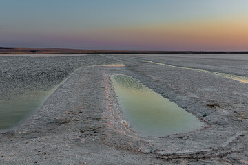 Sunset or sunrise on salt lake Baskunchak (Russia). Landscape in the morning or evening, the shore...